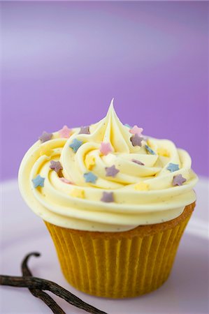 A vanilla cupcake with colourful sugar stars Stock Photo - Premium Royalty-Free, Code: 659-06671411