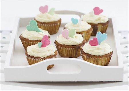 Vanilla cupcakes with glacÈ icing and sugar hearts on a tray Photographie de stock - Premium Libres de Droits, Code: 659-06671517