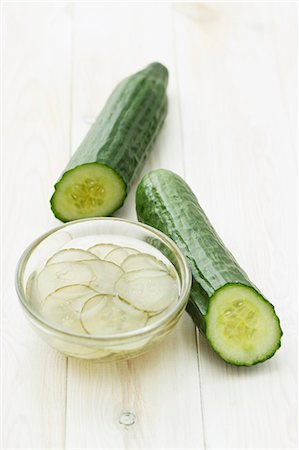 eingemachtes - Two cucumbers and a dish of pickled cucumber slices Stockbilder - Premium RF Lizenzfrei, Bildnummer: 659-06671521