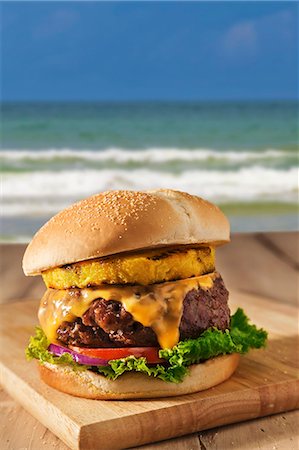 simsearch:659-06153913,k - Cheeseburger with Tomatoes, Red Onion, Lettuce and Grilled Pineapple; By the Beach Stock Photo - Premium Royalty-Free, Code: 659-06671551