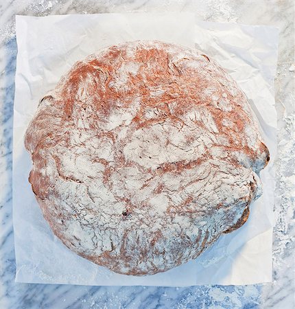 simsearch:659-06671588,k - A loaf of bread on paper, on a marble slab, dusted with flour Stockbilder - Premium RF Lizenzfrei, Bildnummer: 659-06671587