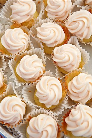 Mini Vanilla Frosted Cupcakes in Paper Liners Photographie de stock - Premium Libres de Droits, Code: 659-06671609