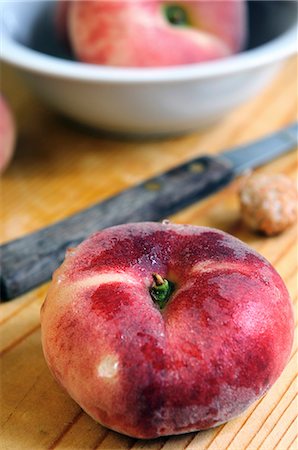 fresh peach - A flat peach and a knife on a chopping board Foto de stock - Sin royalties Premium, Código: 659-06900787