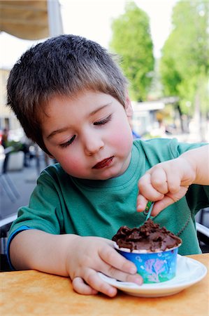 A little boy eating chocolate ice cream in an ice cream cafe Photographie de stock - Premium Libres de Droits, Code: 659-06900781