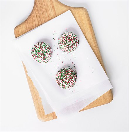 pastry overhead - Three Vanilla Cookies with Christmas Colored Sprinkles; On Parchment on Cutting Board Foto de stock - Sin royalties Premium, Código: 659-06900858