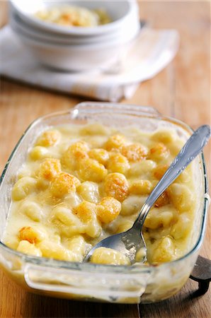 Oven dish of potato gnocchi with fontina, gorgonzola, and taleggio sauce topped with parmesan Foto de stock - Sin royalties Premium, Código: 659-06900888