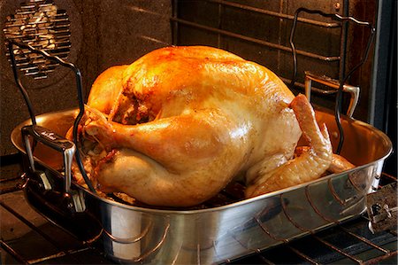 pavo (alimento) - Whole Turkey in a Roasting Pan in the Oven Foto de stock - Sin royalties Premium, Código: 659-06900934