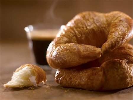 Two Croissants Stacked with a Steaming Espresso in the Background Foto de stock - Sin royalties Premium, Código: 659-06901248