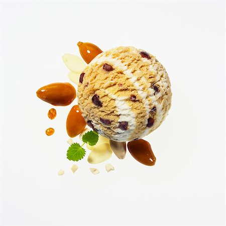 Almond ice cream with caramelised almonds, slivered almonds, whole almonds, caramel drops and lemon balm Photographie de stock - Premium Libres de Droits, Code: 659-06901261