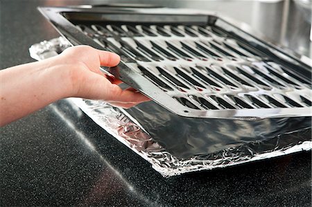 simsearch:659-07028157,k - Placing a Broiler Pan on a Foil Lined Pan Stock Photo - Premium Royalty-Free, Code: 659-06901311