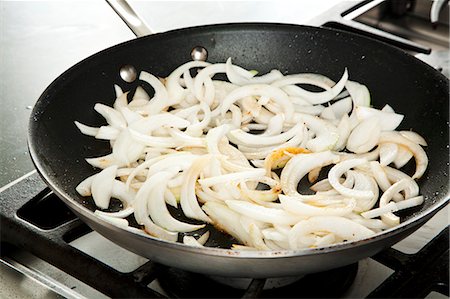 frying pan - Cooking Sliced Onions in a Skillet Stock Photo - Premium Royalty-Free, Code: 659-06901400