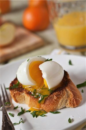 A Soft Boiled Egg Oozing Over Thick Cut Toasted Garlic Bread Foto de stock - Sin royalties Premium, Código: 659-06901491