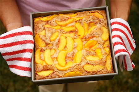 simsearch:659-06186498,k - Woman Holding Fresh From the Oven Peach Cobbler Foto de stock - Royalty Free Premium, Número: 659-06901543