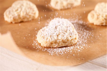 dredging sugar - Dusting heart-shaped biscuits with icing sugar Stock Photo - Premium Royalty-Free, Code: 659-06901686