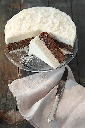 Poppy seed cake topped with coconut mousse, partly sliced Stock Photo - Premium Royalty-Free, Code: 659-06901708