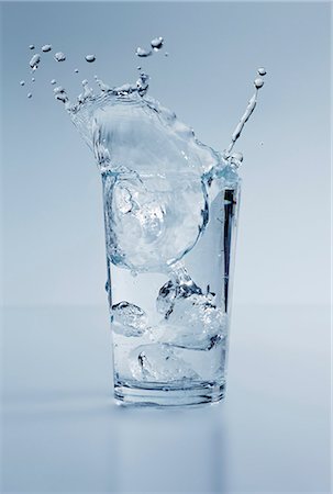 Ice Cubes Splashing into a Glass of Water with a Lemon Wedge Stock Photo - Premium Royalty-Free, Code: 659-06901770