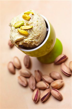 Pistachios in an eggcup with roasted pistachios to one side Photographie de stock - Premium Libres de Droits, Code: 659-06901872