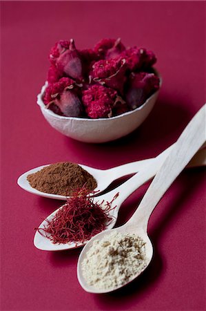 Spoons of liquorice root powder, saffron threads and cinnamon, with a bowl of pomegranate flowers Stock Photo - Premium Royalty-Free, Code: 659-06901895