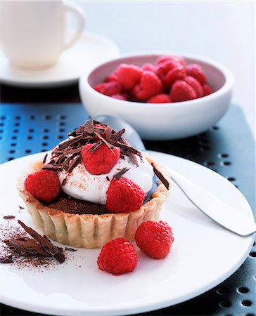 simsearch:659-06903621,k - Individual chocolate torte with cream and raspberries Foto de stock - Sin royalties Premium, Código: 659-06901910
