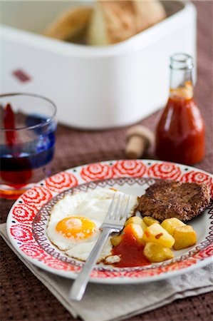 simsearch:659-06903328,k - A fried egg, fried potatoes and Frikadelle (German burger), served with home-made ketchup Foto de stock - Sin royalties Premium, Código: 659-06901986