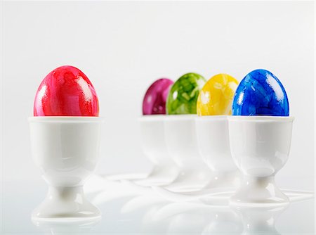 simsearch:659-07028177,k - Five eggs, brightly coloured for Easter, in white eggcups with egg spoons Photographie de stock - Premium Libres de Droits, Code: 659-06902048