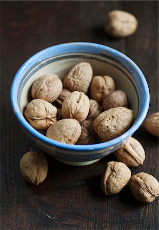 Walnuts in a bowl on a wooden surface Foto de stock - Sin royalties Premium, Código: 659-06902057