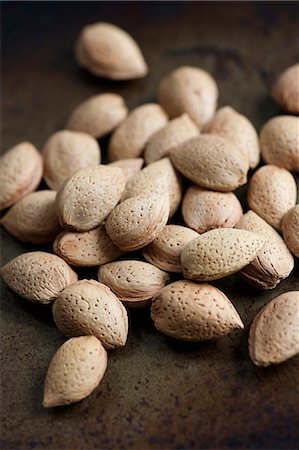 Lots of almonds on a wooden surface Fotografie stock - Premium Royalty-Free, Codice: 659-06902059