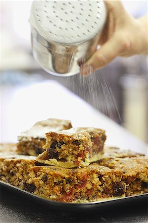 dredging sugar - Dusting fruit cakes with powdered sugar Stock Photo - Premium Royalty-Free, Code: 659-06902147