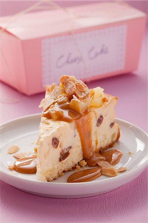 A piece of cheesecake with caramel sauce and slivered almonds Stock Photo - Premium Royalty-Free, Code: 659-06902295