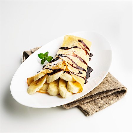 simsearch:659-01854693,k - Crepe with banana slices and chocolate sacue Fotografie stock - Premium Royalty-Free, Codice: 659-06902325
