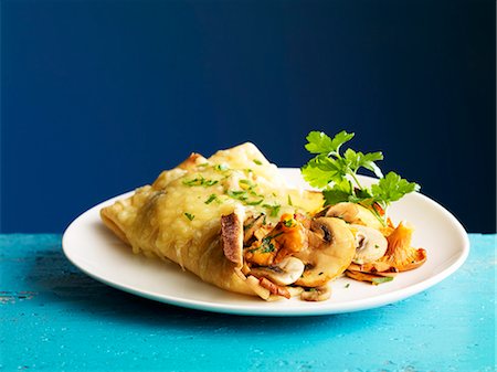 Crepes stuffed with mushrooms and gratinated with cheese Foto de stock - Sin royalties Premium, Código: 659-06902328