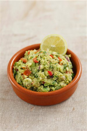 Classic Guacamole in a Glass Bowl; Fresh Avocados Stock Photo - Premium Royalty-Free, Code: 659-06902449