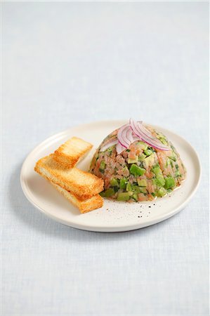 simsearch:659-06155632,k - Smoked salmon and avocado tartar topped with onions and served with toast Foto de stock - Royalty Free Premium, Número: 659-06902785