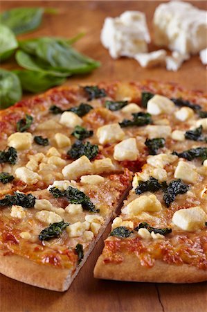 simsearch:659-06902903,k - Spinach and Feta Cheese Pizza Sliced Once Foto de stock - Sin royalties Premium, Código: 659-06902907