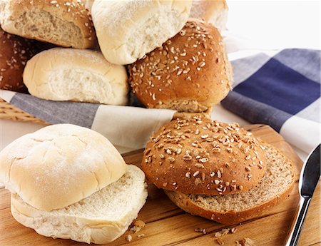 Assorted rolls, some sliced in half, some in a bread basket Photographie de stock - Premium Libres de Droits, Code: 659-06903122