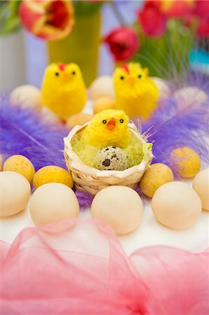 simsearch:659-07596990,k - still life arrangement of Easter simnel cake with pink chiffon ribbon and yellow chicks with spring tulips Stock Photo - Premium Royalty-Free, Code: 659-06903202