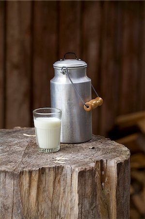 A milk churn and a milk glass on a rustic wooden block Stock Photo - Premium Royalty-Free, Code: 659-06903448