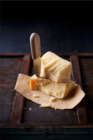 Stacked chunks of parmesan on dry flatbread, with a cheese knife stuck into one of the chunks of cheese Photographie de stock - Premium Libres de Droits, Code: 659-06903450