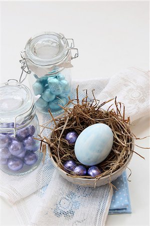 easter eggs candy - Mini chocolate eggs in preserving jars and a painted egg in a nest for Easter Stock Photo - Premium Royalty-Free, Code: 659-06903496