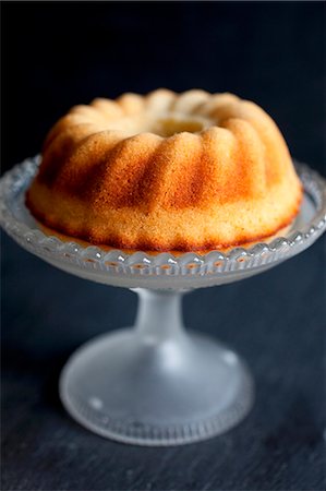 Mini lemon sponge bundt cake on vintage glass cake stand Stock Photo - Premium Royalty-Free, Code: 659-06903523
