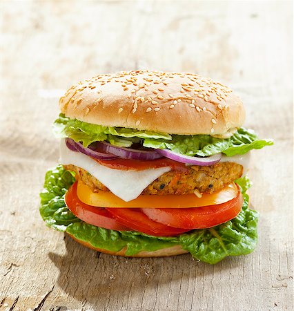 A vegetarian burger with a vegetable patty and goat's cheese, on a wooden surface Stock Photo - Premium Royalty-Free, Code: 659-06903583