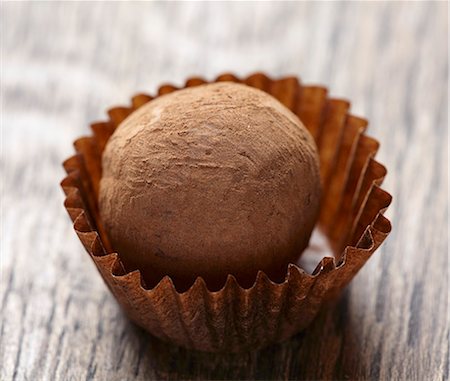 dulce de chocolate - Close up of chocolate truffle on brown wooden table Foto de stock - Sin royalties Premium, Código: 659-06903606