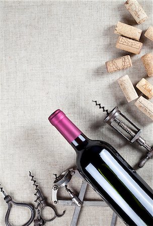 A bottle of red wine, old corkscrews and wine corks Stock Photo - Premium Royalty-Free, Code: 659-06903600