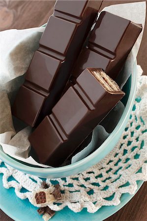schokoriegel - Bars of chocolate on paper in a bowl Foto de stock - Sin royalties Premium, Código: 659-06903619