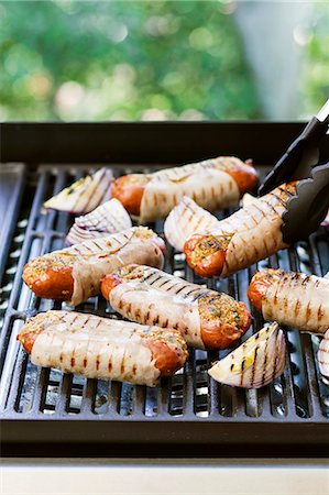 Stuffed sausages wrapped in ham on the barbecue Stock Photo - Premium Royalty-Free, Code: 659-06903686