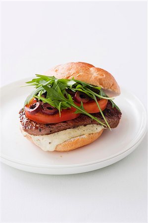 A burger with rump steak, tomatoes, olives and rocket (Italy) Photographie de stock - Premium Libres de Droits, Code: 659-06903706