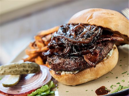 Hamburger Topped with Caramelized Onions; With Pickles and Fries Stock Photo - Premium Royalty-Free, Code: 659-06903776