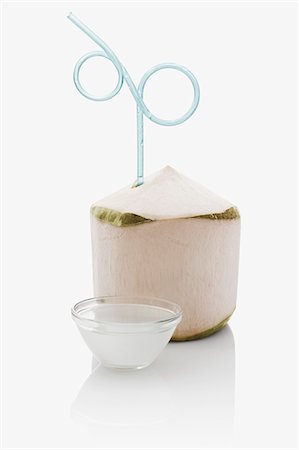 simsearch:659-06307348,k - A peeled coconut with a drinking straw and a small bowl of coconut water Stock Photo - Premium Royalty-Free, Code: 659-06903886