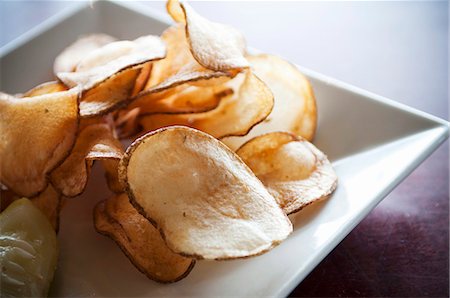 simsearch:659-06186794,k - Fresh Cut Potato Chips on a White Dish Photographie de stock - Premium Libres de Droits, Code: 659-07026780