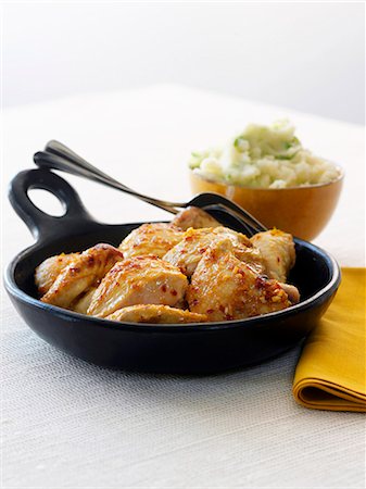 simsearch:659-07026826,k - Honey Glazed Chicken in a Cast Iron Skillet; Bowl of Mashed Potatoes in the Background Fotografie stock - Premium Royalty-Free, Codice: 659-07026826